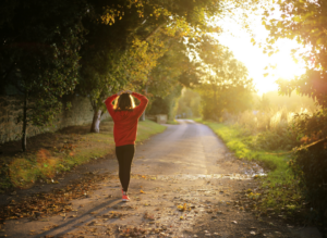 stories we tell ourselves - woman walking down a country lane, her back is to the camera, she is deep in thought
