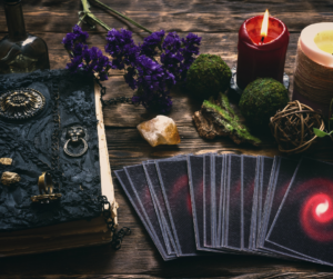 tarot cards, red candle, leather bound journal, set out for tarot journaling